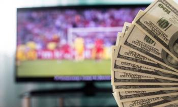 Dollar bills and football on TV
