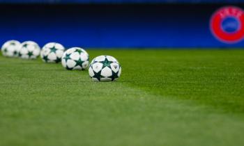 Champions League balls on football pitch.